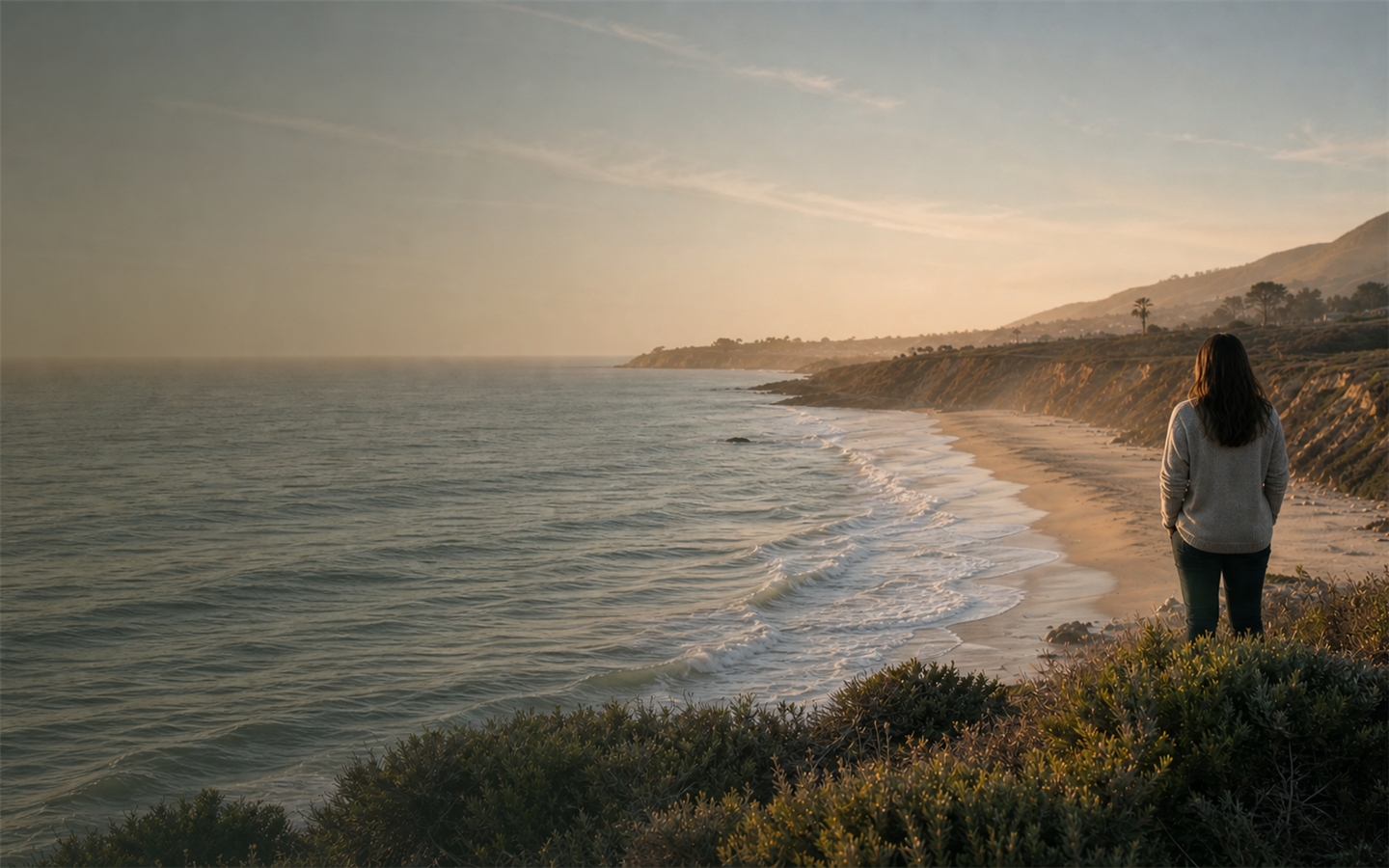 A person overlooking the Pacific Ocean along an Orange County coastline