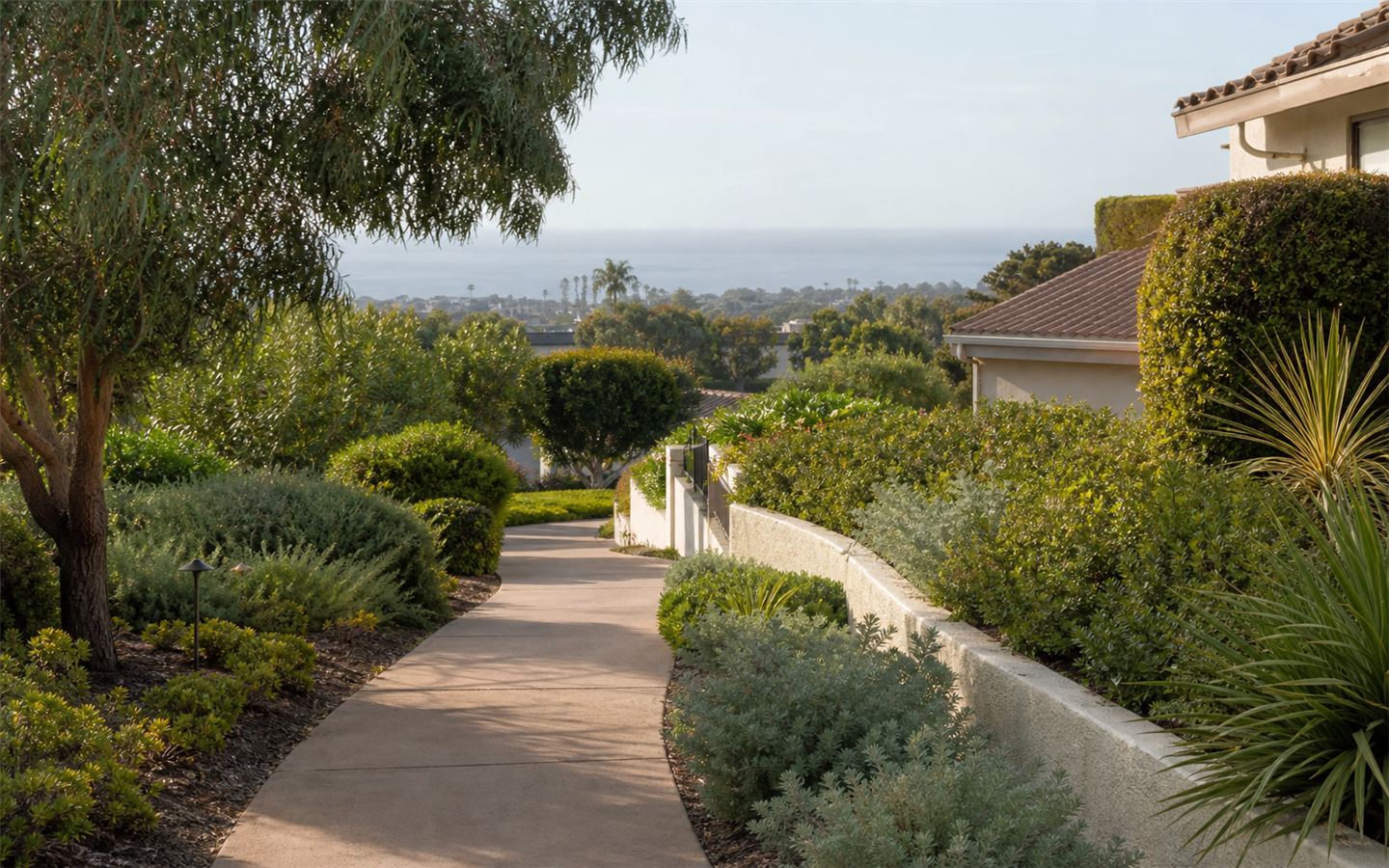 A landscaped Orange County community walkway with the ocean in the distance