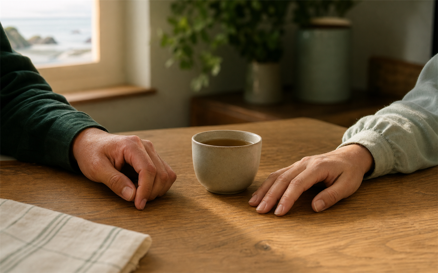 A supportive hand resting near a warm cup of tea in a calm room
